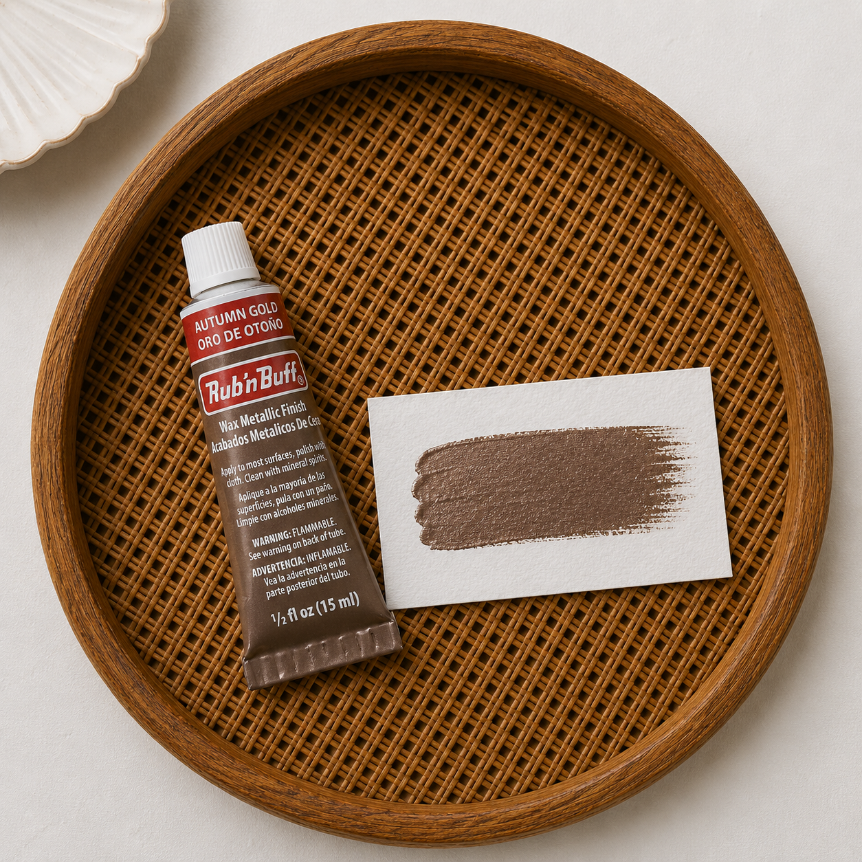 Rubin Buff wax metallic finish tube and swatch on a woven wooden tray